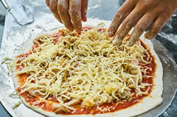 Pizza mit Toppings belegen